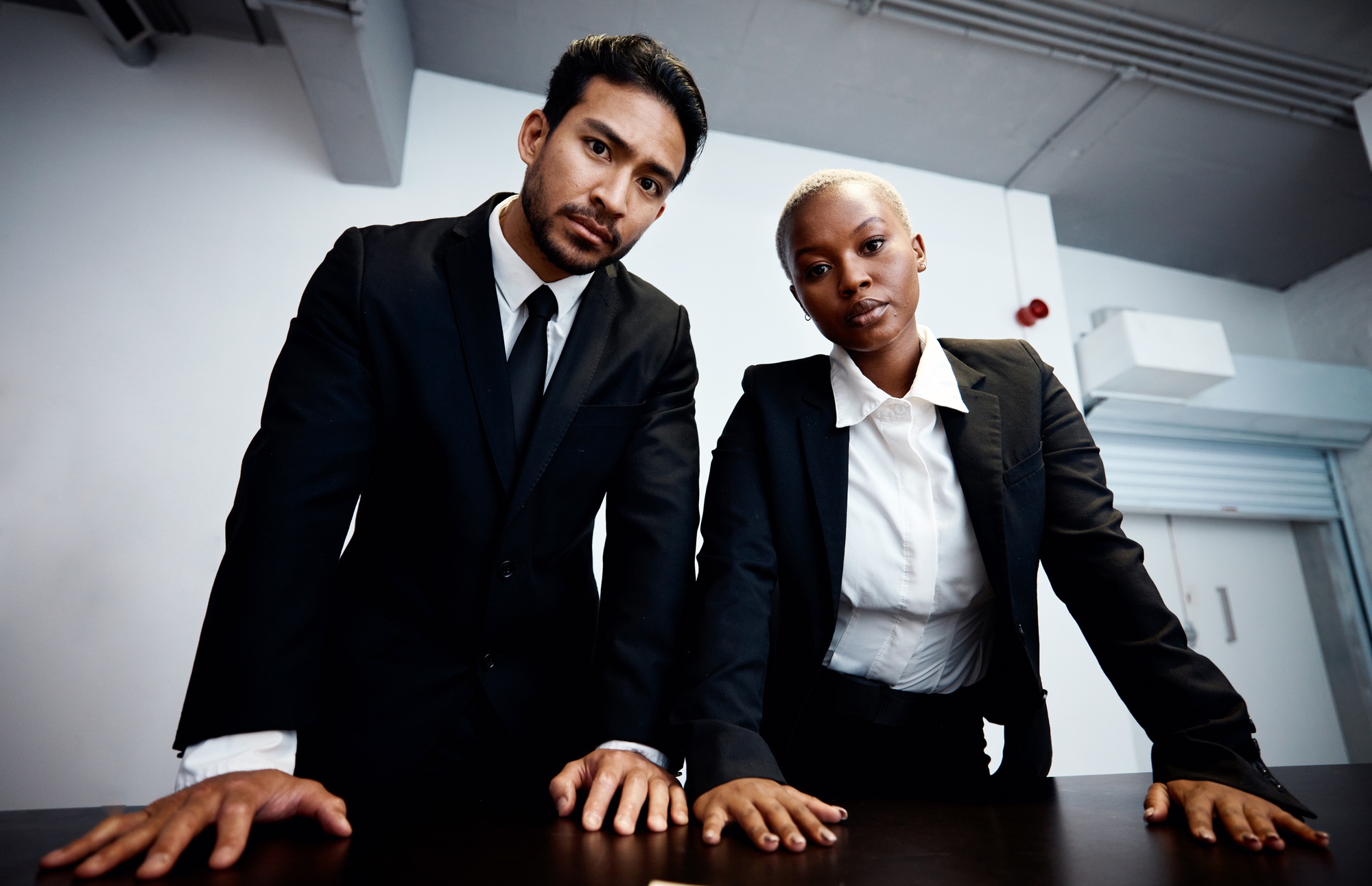 Police detective, man and woman in interrogation room, portrait and together with teamwork for info